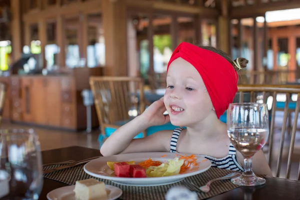 Liebenswertes kleines Mädchen frühstückt im Café im Freien — Stockfoto