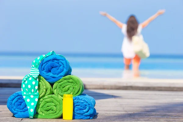 Spiaggia e accessori estate concetto asciugamani colorati, costume da bagno e crema solare sfondo bella donna — Foto Stock