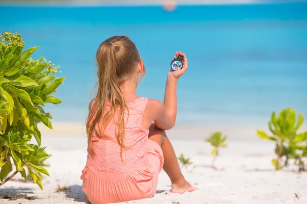 Bambina viaggiatrice con una bussola in mano sulla spiaggia — Foto Stock