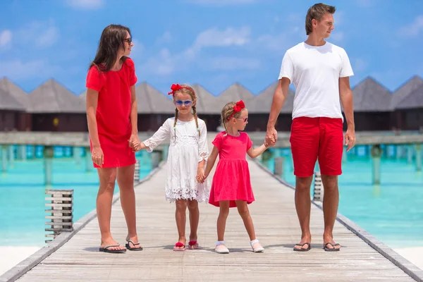 Krásná rodina v červeném baví na dřevěné molo během letních prázdnin — Stock fotografie