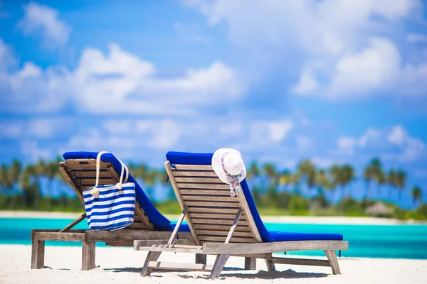 Lounge stoelen met zak en hoed op tropische witte strand — Stockfoto