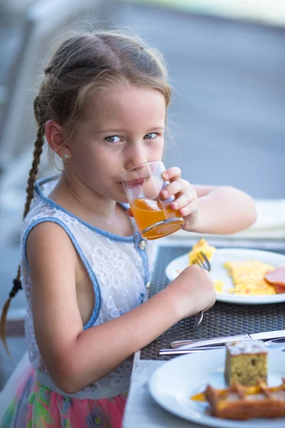 Adorável menina tomando café da manhã no café ao ar livre — Fotografia de Stock