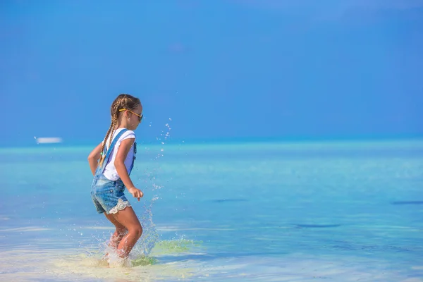 愛らしい幸せな少女が海辺での休暇の楽しい時を過す — ストック写真