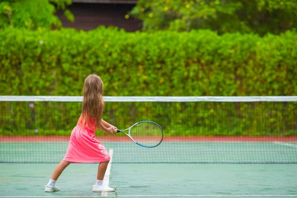 Niña jugando al tenis en la cancha —  Fotos de Stock