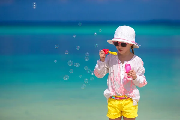 Красивая маленькая девочка делает мыльные пузыри во время летних каникул — стоковое фото