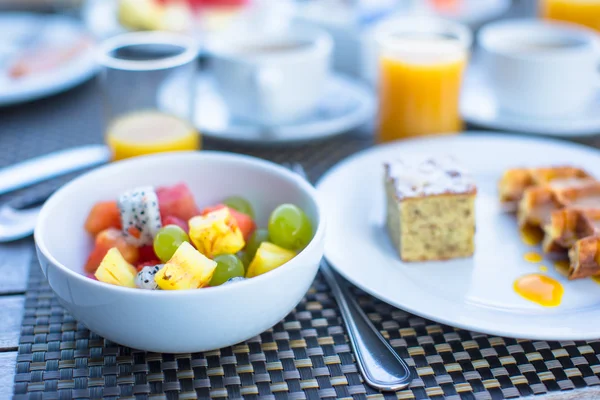 Sałatki ze świeżych owoców, gofry, ciasta, kawa i sok serwowane śniadanie w restauracji resort — Zdjęcie stockowe