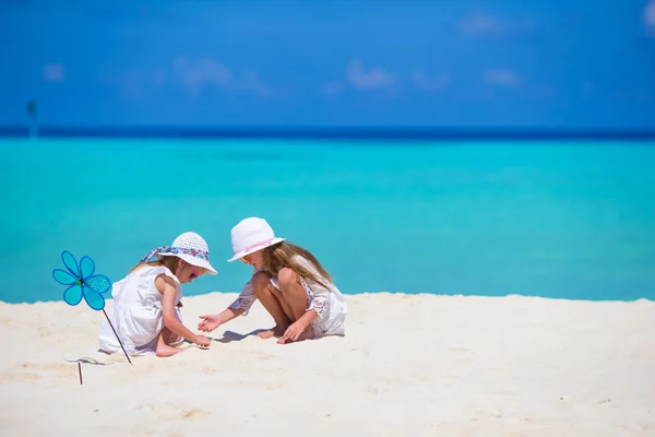Little adorable girls drawing picture on white beach — Stock Photo, Image