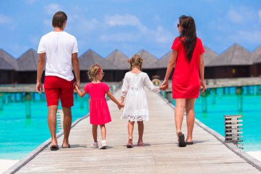 Güzel aile eğleniyor ahşap iskelede yaz tatili kırmızı