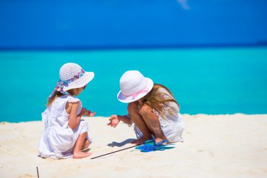 Çok güzel kız beyaz kumsalda resim çizim