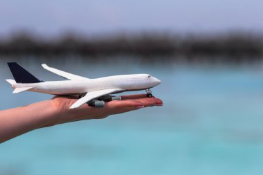 Turkuaz deniz arka plan üzerinde küçük beyaz oyuncak uçak