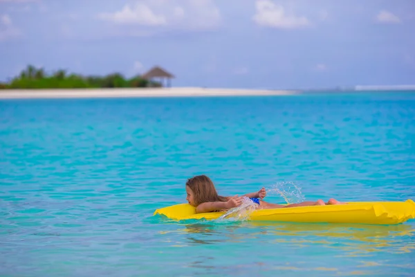 Entzückendes kleines Mädchen auf aufblasbarer Luftmatratze im Meer — Stockfoto