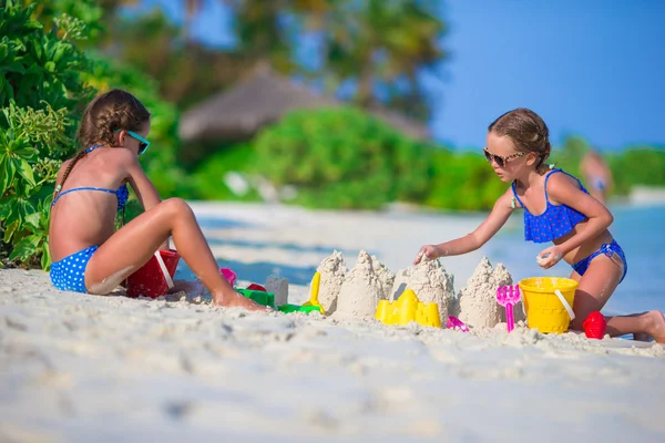 Meninas bonitos brincando com brinquedos de praia durante as férias tropicais — Fotografia de Stock