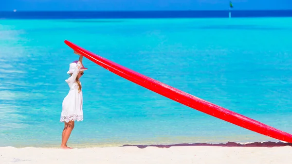 Rozkošná holčička s červeným velké Surf na tropické pláži s bílým — Stock fotografie