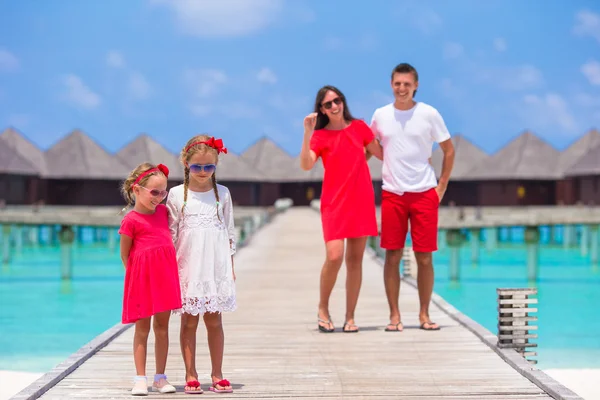 Giovane famiglia di quattro persone si divertono sul molo di legno durante le vacanze estive — Foto Stock