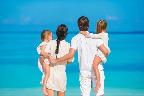 Mladá čtyřčlenná rodina na dovolené na pláži — Stock fotografie
