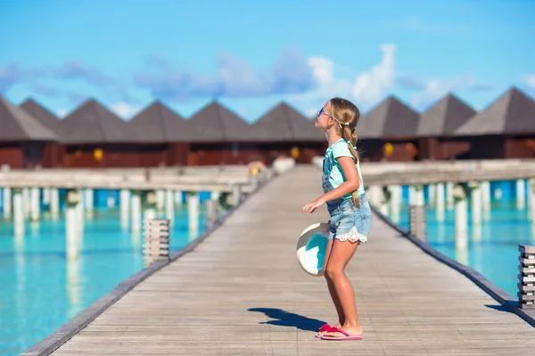 Entzückendes kleines Mädchen hat Spaß auf Holzsteg in der Nähe von Wasser-Bungalow — Stockfoto