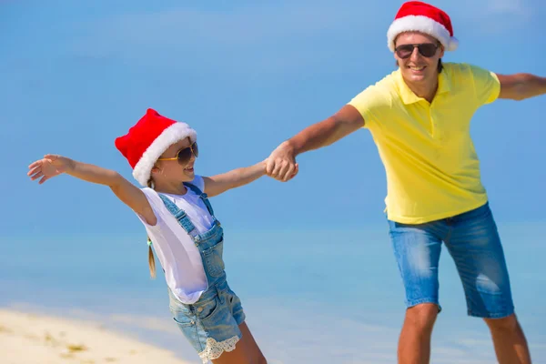 Little girl and happy dad in Santa Hat during beach vacation — Stock Photo, Image