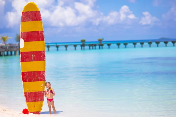 Entzückendes kleines Mädchen mit großem Surfbrett im Tropenurlaub — Stockfoto