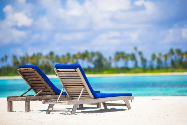 Lounge chairs with bag and hat on tropical white beach — Stock Photo, Image