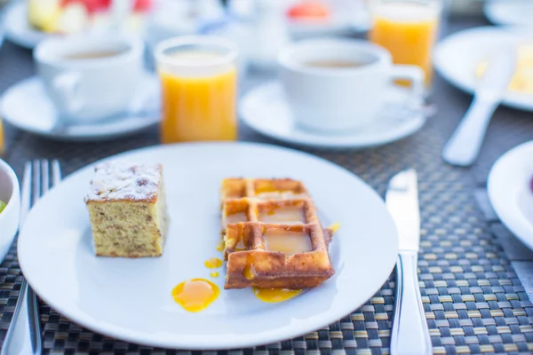 Delicious waffles, cake, coffee and juice served for breakfast at resort restaurant — Stock Photo, Image