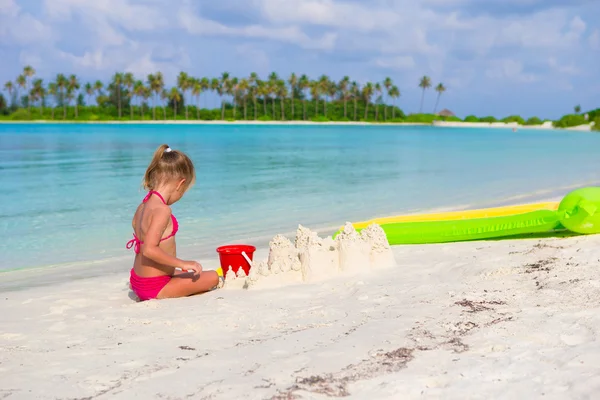 Adorável menina brincando com brinquedos de praia durante as férias tropicais — Fotografia de Stock