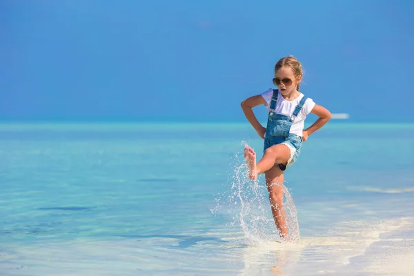 Schattig gelukkig meisje veel plezier hebben in ondiep water op strandvakantie — Stockfoto