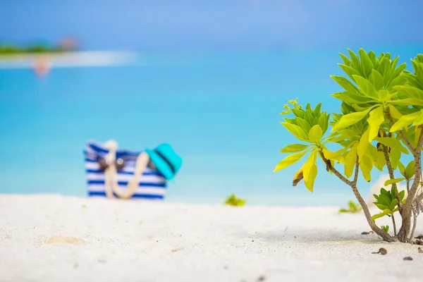 Acessórios de praia - saco azul, chapéu de palha, óculos de sol na praia branca — Fotografia de Stock