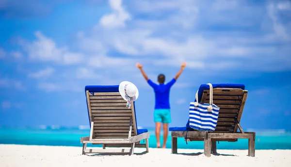 Lounge chairs with bag and hat on tropical white beach — Stock Photo, Image