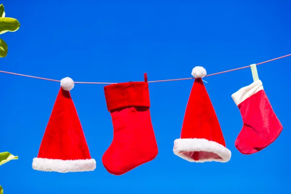 Röd Santa hattar och Julstrumpa hänger på tropical beach — Stockfoto
