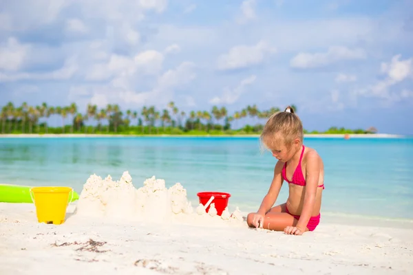 Adorable niña jugando con juguetes de playa durante las vacaciones tropicales —  Fotos de Stock