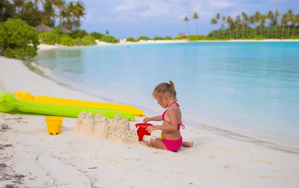 Adorável menina brincando com brinquedos de praia durante as férias tropicais — Fotografia de Stock