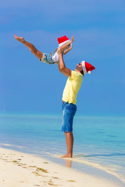 Little girl and happy dad in Santa Hat during beach vacation — Stock Photo, Image