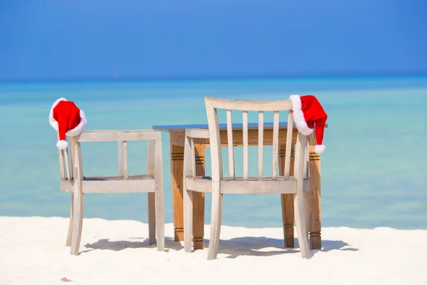 Chapéus de Papai Noel vermelho na cadeira de praia em férias tropicais — Fotografia de Stock