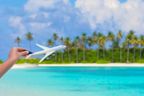 Små vita miniatyr av ett flygplan på bakgrund av turkosa havet — Stockfoto