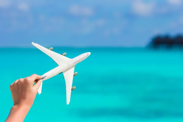 Pequeña miniatura blanca de un avión sobre fondo de mar turquesa —  Fotos de Stock