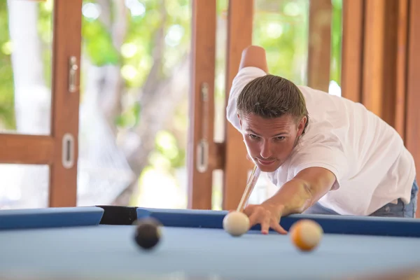 Giovane uomo che gioca a biliardo in vacanza estiva — Foto Stock