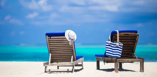 Lounge chairs with bag and hat on tropical white beach — Stock Photo, Image