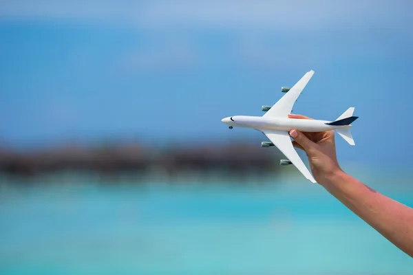 Kleine witte speelgoed vliegtuig op achtergrond van de turquoise zee — Stockfoto