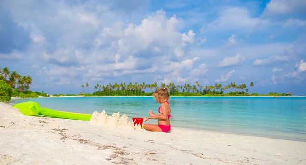 Adorável menina brincando com brinquedos de praia durante as férias tropicais — Fotografia de Stock