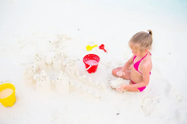 Adorable niña jugando con juguetes de playa durante las vacaciones tropicales —  Fotos de Stock