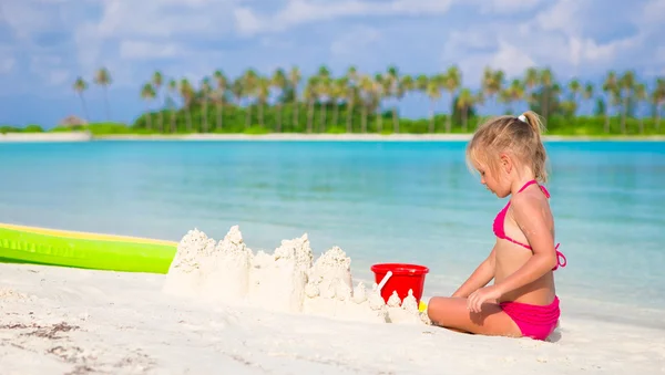 Adorable little girl playing with beach toys during tropical vacation — Stock Photo, Image