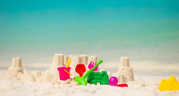 Sandcastle en la playa blanca con juguetes de plástico para niños — Foto de Stock