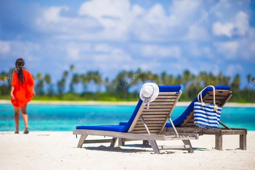 Beautiful young woman relaxing at beach chairs