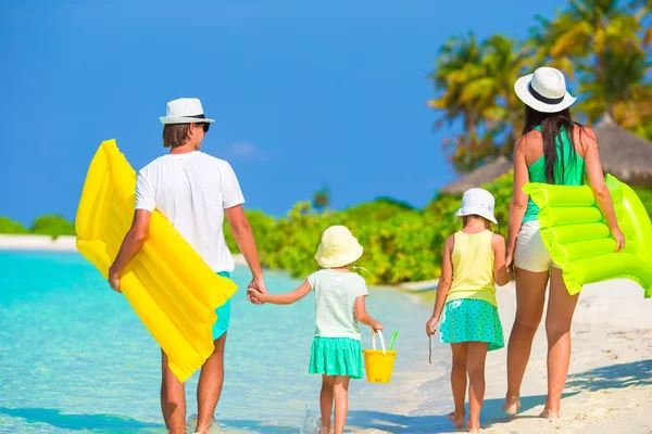 Happy beautiful family on white beach with air mattresses — Stock Photo, Image