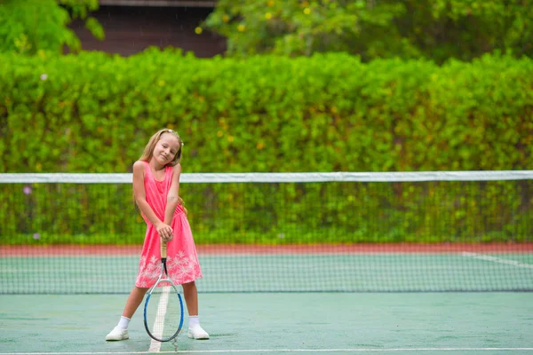 Niña jugando al tenis en la cancha —  Fotos de Stock