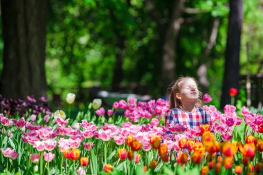 Lale yemyeşil bahçesinde küçük sevimli kız