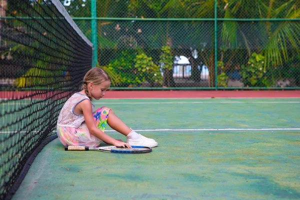 Little girl trying to play tennis on outdoor court — Stock Photo, Image