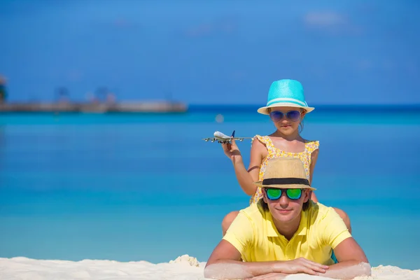 Young man and little girl with miniature of airplane at beach — Stock Photo, Image