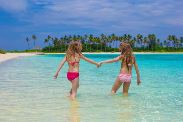 Adorable happy little girls have fun at shallow water on beach vacation — Stock Photo, Image