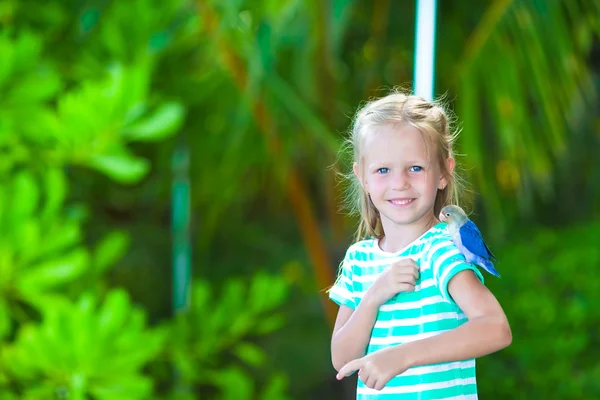 Adorable fille heureuse à la plage avec petit oiseau coloré — Photo